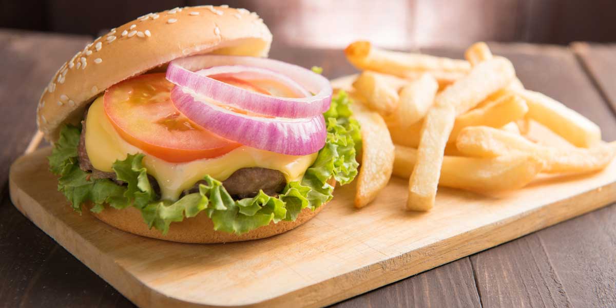BBQ hamburgers with french fries on wooden background.